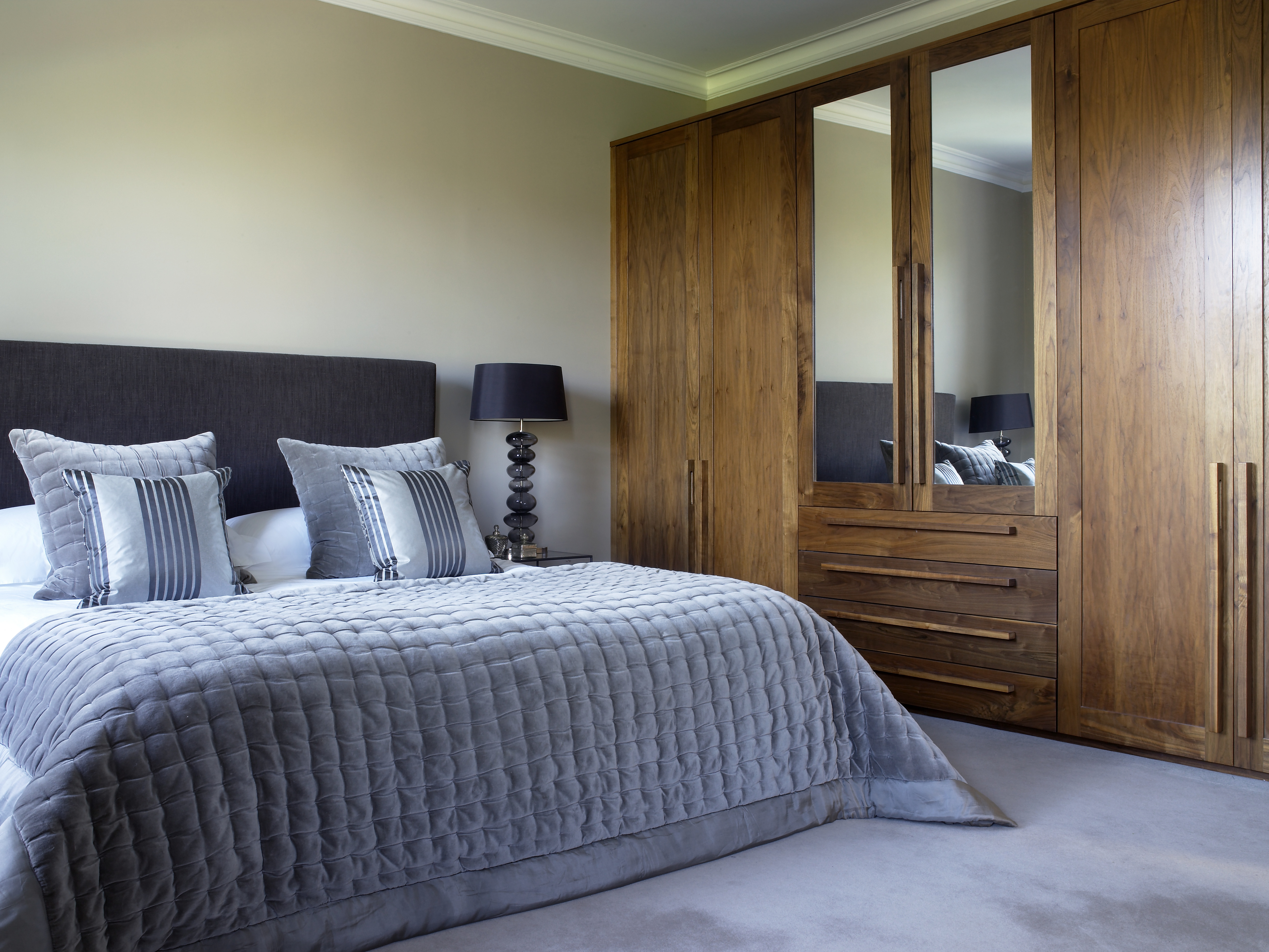 Master bedroom with smoked glass pebble bedside lamps and bespoke walnut wardrobes.