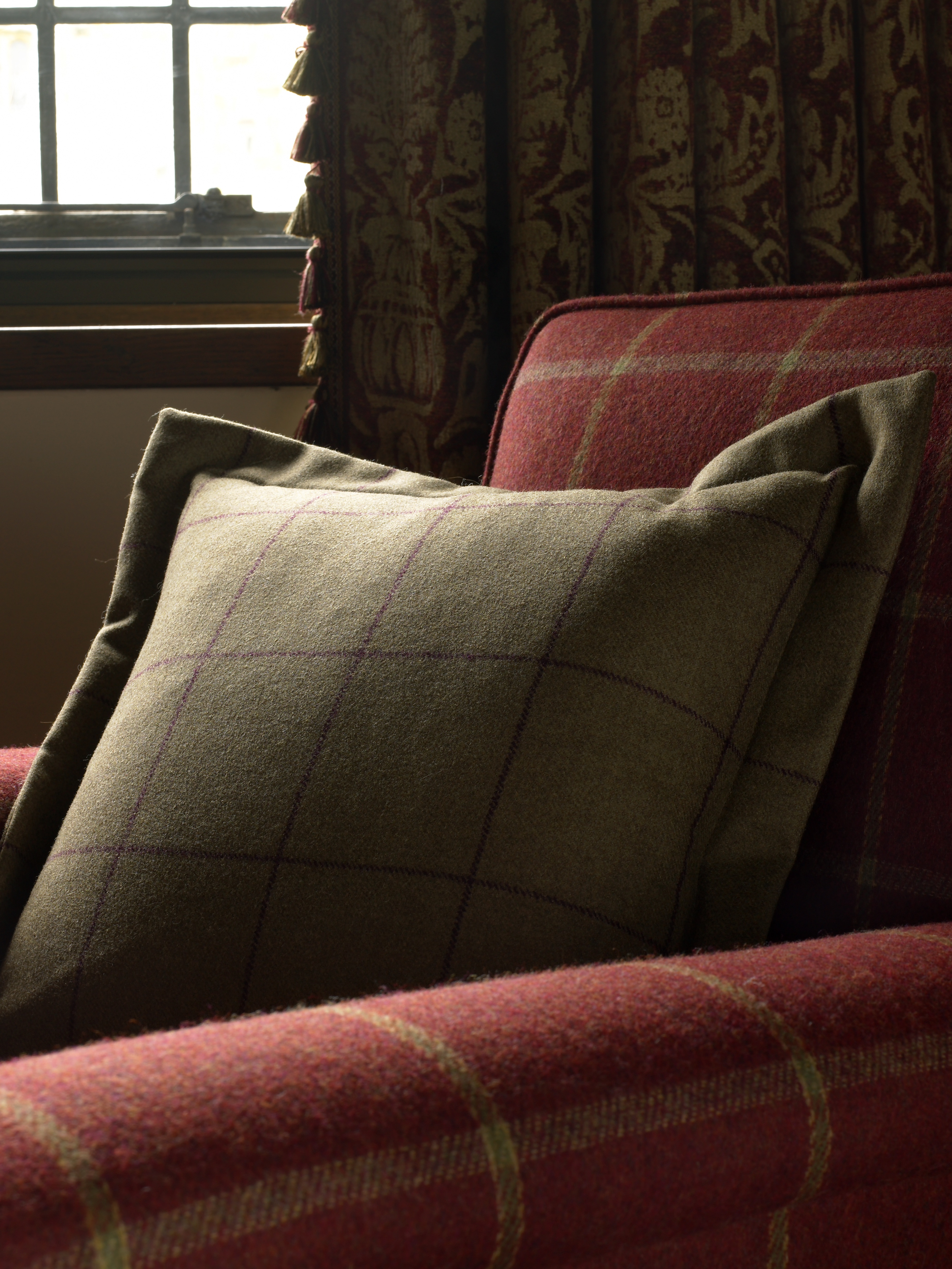 Wool check fabrics on armchair and cushion in classical room scheme.