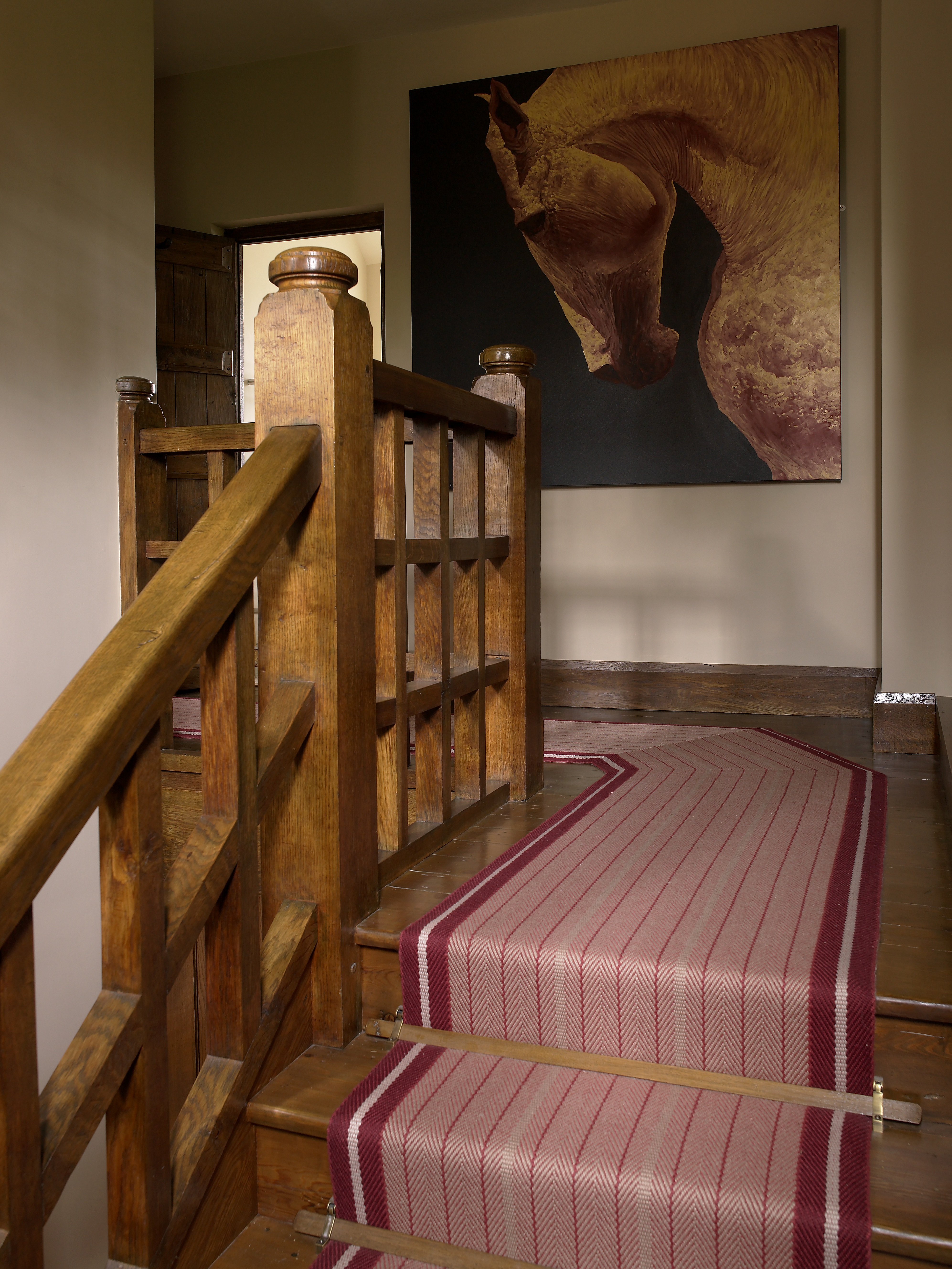 Striped runner by Roger Oates in hallway with oak beams and antique chest.